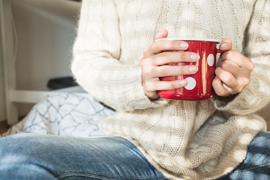 Žena so šálkou teplého čaju v rukách